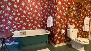 A bathroom with a freestanding bathtub, a toilet, and a sink.