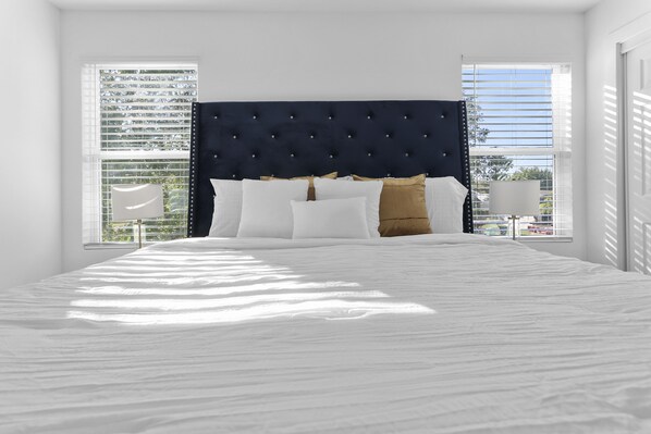 Relax in a serene bedroom with a large bed and a clean, minimalist design.