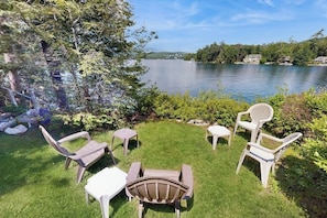 A lakeside patio with outdoor furniture and a view of the lake.