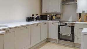 A kitchen with a microwave, toaster, kettle, and oven. - 2 bedroom accommodation in Hothfield (Hothfield)
