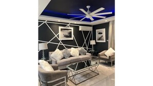 A modern living room with a geometric wall design, a ceiling fan, and a glass coffee table. - Luxurious 1 bedroom condo. On the South (Kingston)