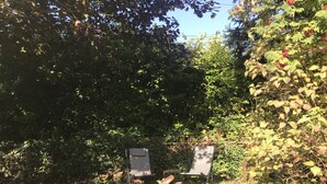 A garden area with two empty chairs and a wooden post. - King Bed Private Suite - Seattle North Ballard (Seattle)