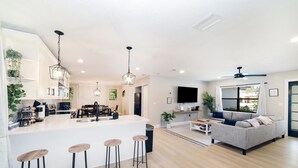 A modern kitchen with a central island, bar stools, and pendant lighting. - ☆New☆6min to 3 Sisters Springs☆Spacious, Fun with Game room (Crystal River)