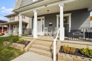 A two-story house with a covered porch, steps leading to the entrance, and outdoor seating. - *BRAND NEW* The Frances Rose | Hocking Hills Luxury | Family Friendly! (Logan)