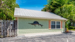 A small, single-story building with a green exterior and a metal roof. - The Roosevelt Suite (2 BEDROOMS/2 BATHS) (Stuart)