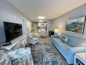 Relax in this stylish living room with a flat-screen TV, comfortable sofa, and dining area.