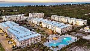Um resort com vários edifícios, uma piscina e vista para o oceano.