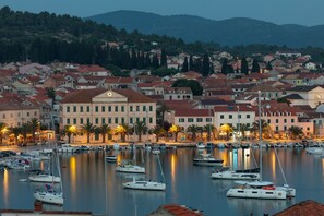 Un puerto deportivo con barcos amarrados, rodeado de edificios con tejados rojos y un edificio destacado con una torre del reloj.
