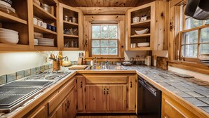 Une cuisine en bois, dotée de placards intégrés, d’une cuisinière et d’un lave-vaisselle.