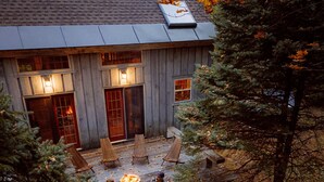 Un chalet rustique doté d’une terrasse, d’un espace salon extérieur et d’un foyer.