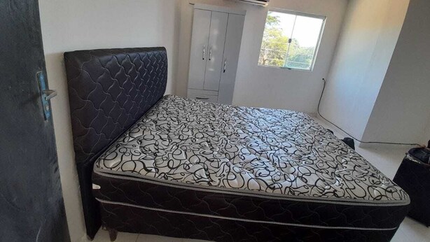 A bedroom with a bed, wardrobe, and air conditioning unit. - 5 minutes from the airport, the comercial city, is a place will be in pace, save (Luque)