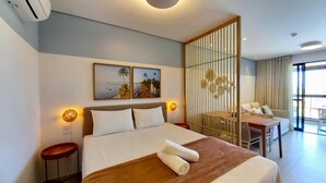 Une chambre d’hôtel avec un lit, un bureau, une chaise et une grande fenêtre.