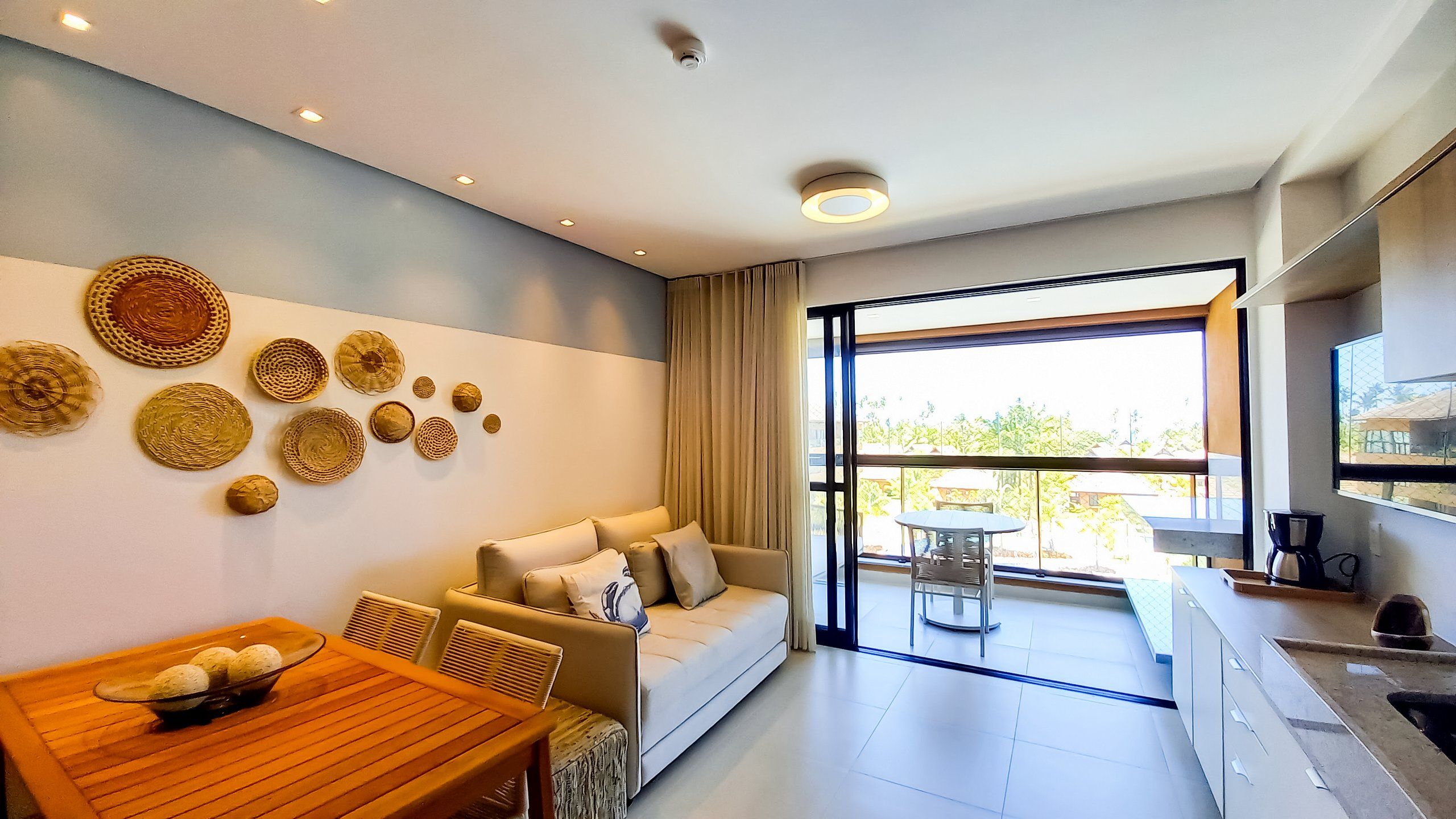 Een moderne woonkamer met een bank, eettafel en decoratieve wandkunst.