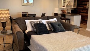 A modern living room with a sofa, two pillows, a side table, and a lamp. - Lakefront Apartment on Beautiful Lake Tapps, Spectacular Views (Bonney Lake)