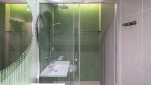 A modern bathroom with a glass-enclosed shower, a sink, and a mirror. - Kolokotroni Lofts Syntagma (Athens)