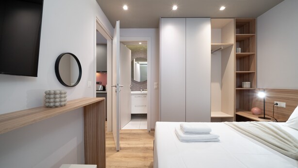 A modern bedroom with a bed, bedside table, and a wardrobe. - Kolokotroni Lofts Syntagma (Athens)