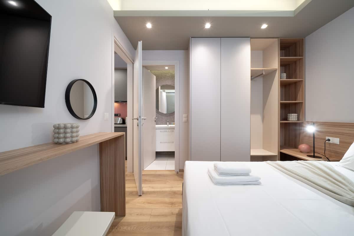 A modern bedroom with a bed, bedside table, and a wardrobe.