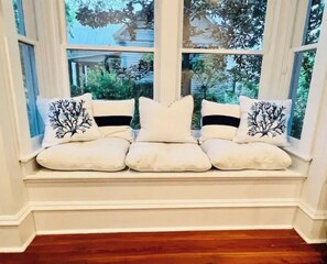 Sit comfortably in this inviting seating area with a bench and enjoy the view of the surrounding trees and a nearby house.