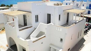 A white building with multiple balconies and a view of the sea. - Spacious 2BR Flat, Pergola Veranda, 20m to Agios Prokopios Beach (Naxos)