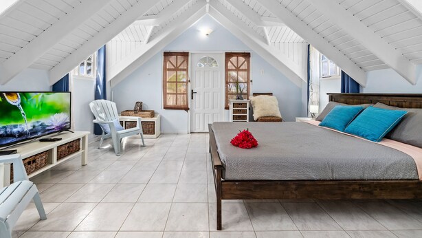 Une chambre à coucher avec un lit, une télévision, une chaise et un bureau.