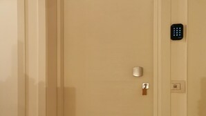 Une porte fermée, dotée d’un clavier pour la serrure et d’un petit interrupteur d’éclairage sur le mur.