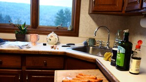 A kitchen counter with carrots, a knife, and kitchen items.