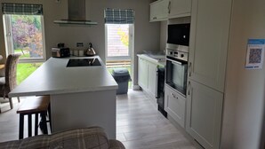 Una cocina moderna con una isla central, horno integrado y vistas al jardín.