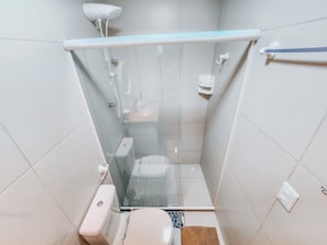 A compact bathroom with a glass-enclosed shower, a toilet, and a bidet. - Lindos apartamentos no Porto Cayman (Tamandaré)