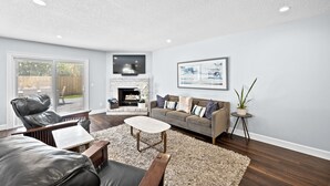 Een moderne woonkamer met een open haard, een leren bank en een bijzettafeltje.