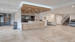 A spacious lobby with a wooden reception desk, a staircase, and a coffee station. - Staybridge Suites Federal Way - Seattle South by IHG (Federal Way)