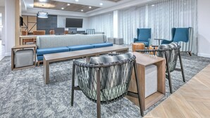 A modern living room with a sofa, two armchairs, a coffee table, and a TV. - Staybridge Suites San Antonio Lackland AFB Area by IHG (San Antonio)