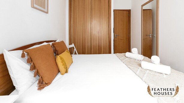 Un dormitorio con una cama grande, un armario de madera y un espejo.