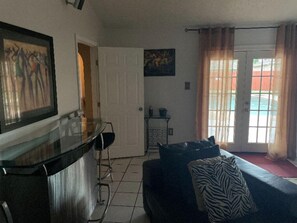 Cozy living space with a kitchenette, sofa, and sliding glass door leading to an outdoor area.