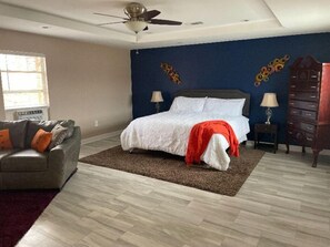 Relax in this serene bedroom with a large bed, bedside tables, and a ceiling fan.