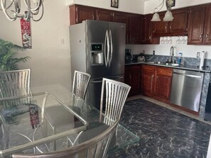Enjoy cooking in this well-equipped kitchen with a refrigerator, water dispenser, and sink.