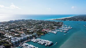 An aerial view of a coastal marina with numerous boats docked, surrounded by residential buildings and a beach. - 1 Block to the BEACH! King Beds! BBQ! (West Palm Beach)