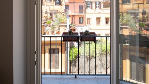 A balcony with potted plants and a view of neighboring buildings. - Valeria Terrace   Monti, Rome (ROMA)
