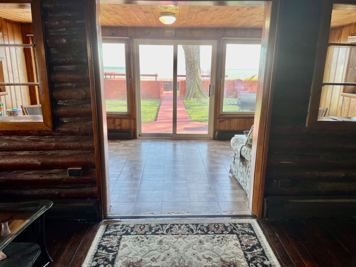 A wooden interior with a large glass door leading to a patio area.