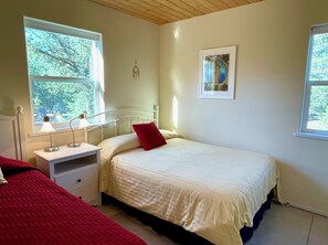 A bedroom with a bed, bedside tables, a nightstand, a window, and a wall-mounted artwork. - Escape to the Extraordinary in NM! (Carson)