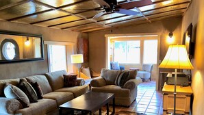A cozy living room with a sofa set, a coffee table, and a patterned armchair. - Ranch House Respite outside Taos, New Mexico! (Carson)