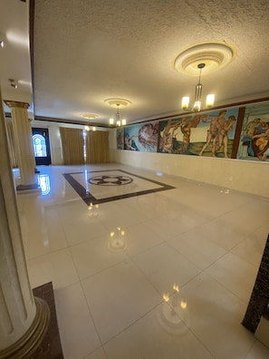 Experience the grandeur of our lobby, featuring a stunning mural and elegant columns.
