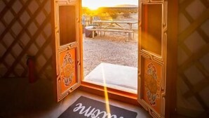 A room with a large wooden door leading to an outdoor area. - 28 Palms Ranch (Twentynine Palms)