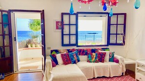 A room with a bed, a window with a view of the sea, and a door leading outside. - Spacious Beachfront Villa (Porto Columbu-Perd'È Sali)