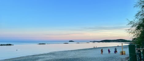 Rannalla, aurinkotuoleja, rantapyyhkeitä