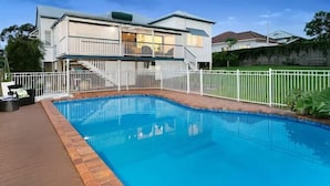 A modern two-story house with a swimming pool and a white fence. - The Indooroopilly Queenslander 4BDR Home (Indooroopilly)