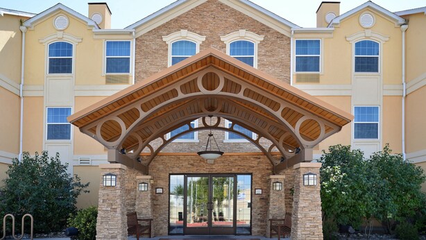 A building with a stone facade, large windows, and a covered entrance with a wooden roof. - 1 Bedroom | Indoor Pool + Hot Tub Access (Albuquerque)