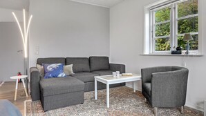 A modern living room with a grey sofa, a white coffee table, and a patterned rug. - Awesome apartment in Allinge with WiFi (Allinge)