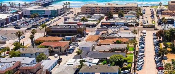 An aerial view of a coastal urban area with multiple buildings, parking lots, and a beach in the background. - 1 Block to Beach/Restaurants/Bars, Remodeled, 2-Car Garage w/fee, Yard, Sleep 10 (San Diego)