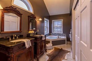 A bathroom with two sinks, a large bathtub, and a mirror above the sink.