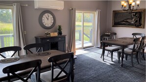 Un comedor con una mesa y sillas, un reloj en la pared y vistas al exterior.